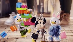 three stuffed animals standing next to each other on a brick floor with blocks in the background