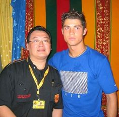 two men standing next to each other in front of colorful curtains