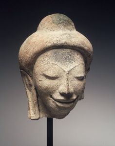 an ancient head is displayed on a stand