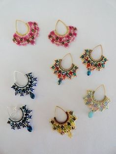 six pairs of beaded earrings on a white surface