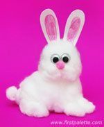 a white stuffed rabbit sitting in front of a pink background