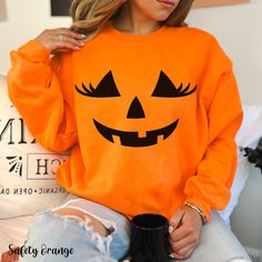 Get into the spooky spirit with our Halloween Pumpkin Sweatshirt, featuring an adorable pumpkin face graphic design complete with eyelashes! This cute fall sweatshirt is perfect for adding a playful touch to your autumn wardrobe. Our pumpkin crewneck is made from soft, cozy fabric, making it ideal for chilly days at the pumpkin patch or casual gatherings. This pumpkin sweater is not just for Halloween--it's a versatile autumn sweatshirt that you can enjoy throughout the season. Whether you're lo Fall Sweatshirt Ideas, Adult Pumpkin Costume, Pumpkin Crewneck, Pumpkin Patch Photoshoot, Pumpkin Sweater, Pumpkin Carving Party, Laughing Face, Halloween Clothes, Pumpkin Outfit