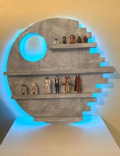 star wars action figures are displayed on shelves in front of a circular blue light behind them