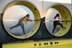 two women are standing in front of large circular mirrors with their legs spread out and one woman is holding on to the handle