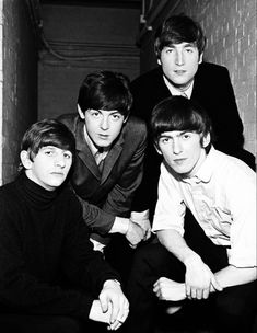 the beatles posing for a black and white photo