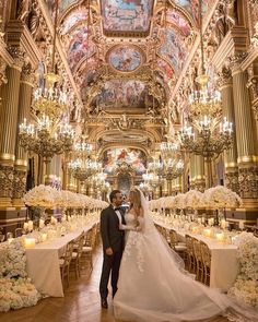 a bride and groom standing in front of an ornate ceiling