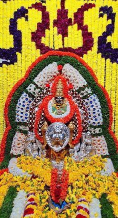 an elaborately decorated statue with flowers and beads