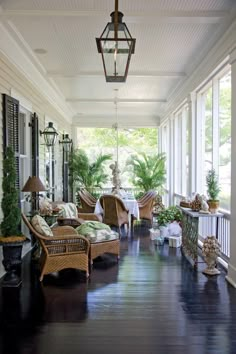 a porch with wicker furniture and potted plants