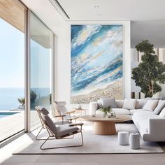 a living room filled with furniture and a large painting on the wall above it's windows