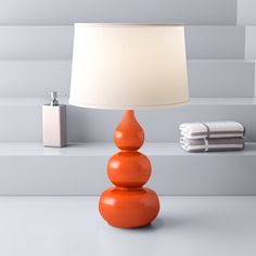 an orange lamp sitting on top of a table