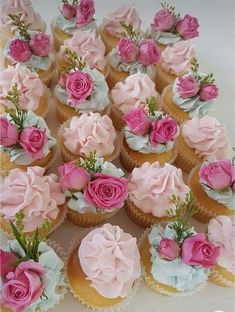 there are many cupcakes with pink flowers on them