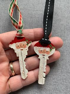 two key shaped like santa claus hanging from a black ribbon on a person's hand