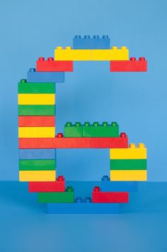 an image of a building made out of legos on a blue background with the letter e