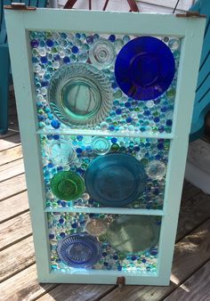 a glass display with plates and bowls on it's sides, sitting on a wooden deck