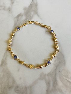 "Perfect worn on its own or layered with our other bracelets. 18k gold filled. Cubic zirconia 7\" length Ready to ship *18k gold filled is a more affordable alternative to solid gold jewelry. Gold filled is a layer of gold bonded onto a base metal with heat and pressure that contains 100+ times more gold than gold plated jewelry.  *It is very durable and tarnish resistant.  *With proper care, gold filled jewelry can last several years. Avoid contact with harsh chemicals, perfumes, water, etc.  *Gold filled jewelry can be worn by people with sensitive skin because it is hypoallergenic, lead free and nickel free." Blue And Gold Bracelets, Gold Star-shaped Celestial Bracelets, Gold Star-shaped Celestial Bracelet, Celestial Gold Star Bracelets, How To Layer Bracelets, Gold And Blue Aesthetic, Gold And Blue Jewelry, Blue And Gold Jewelry, Blue Gold Jewelry