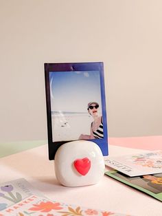 a polaroid with a heart on it sitting next to a card holder