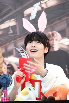 a person with bunny ears holding a cell phone