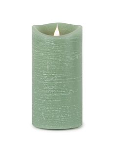 a green candle that is lit on a white background