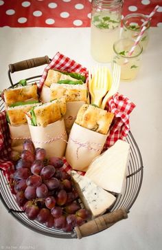 grapes, crackers, cheese and milk are on a plate with red checkered tablecloth