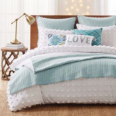 a bed covered in blue and white pillows