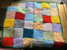 a multicolored crocheted blanket sitting on top of a table