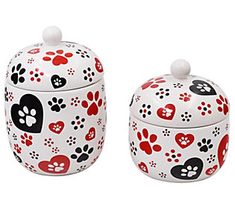 two white ceramic containers with red and black paw prints