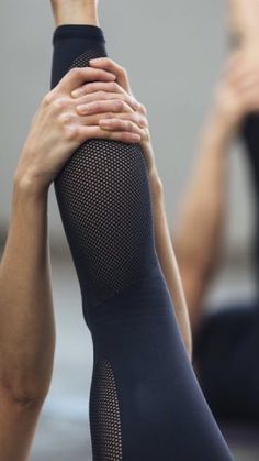 two women doing yoga poses with their hands together