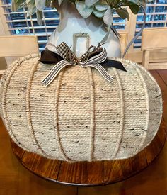 a white pumpkin shaped basket sitting on top of a wooden table