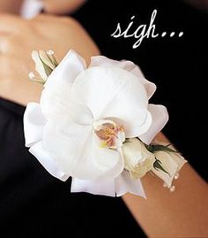 a woman wearing a white flower on her arm