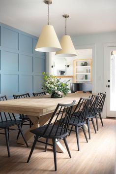 an image of a dining room setting with blue walls and wood table in the center