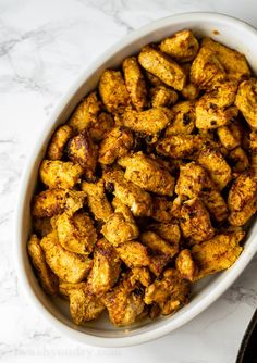 a white bowl filled with chicken sitting on top of a table