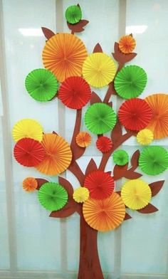 a tree made out of paper with umbrellas on the top and leaves on the bottom