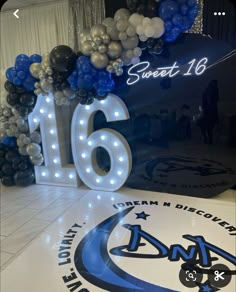 balloons and lights are on the floor in front of a sign that reads sixteen seventyth birthday