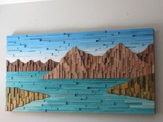 a piece of art made out of wood that looks like mountains and the water is blue