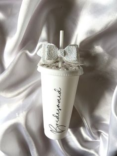 a white cup with a bow on it