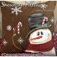 a snowman pillow with candy canes on it