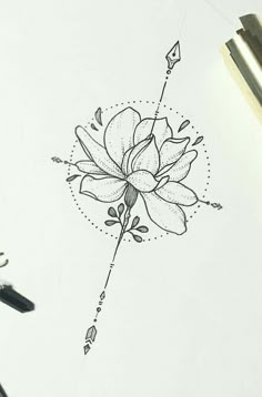 a drawing of a flower on top of a piece of paper next to a pen