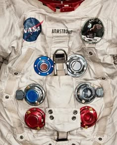 an astronaut's white space suit with red, blue and silver buttons on it