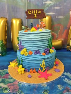 there is a blue cake with fish on it and under the sea decorations around it