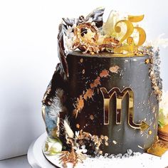 a black cake with gold letters and decorations