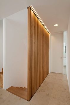 an empty room with wooden slats on the wall and stairs leading up to it