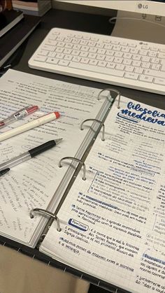 an open notebook sitting on top of a desk next to a keyboard