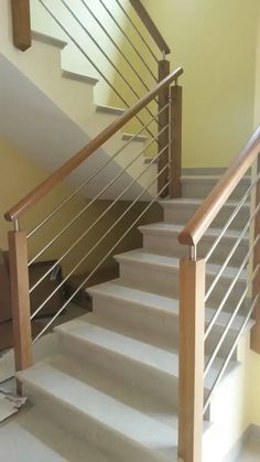 there is a white stair case next to the stairs in this house with yellow walls