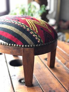 a wooden bench with a colorful cushion on it