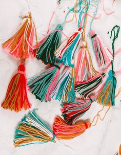 colorful tassels are laid out on the ground for making something to do with them