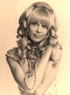 a drawing of a woman with long blonde hair and pearls on her neck, posing for the camera