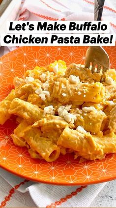 an orange plate topped with pasta covered in cheese and sauce next to a fork on a white table cloth