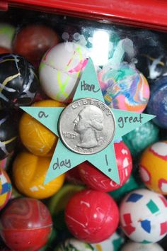 a star shaped coin sitting on top of some colorful easter eggs in a red container