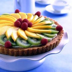 a fruit tart with raspberries and kiwis on top