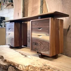 two wooden drawers sitting on top of a piece of wood in a room next to a wall